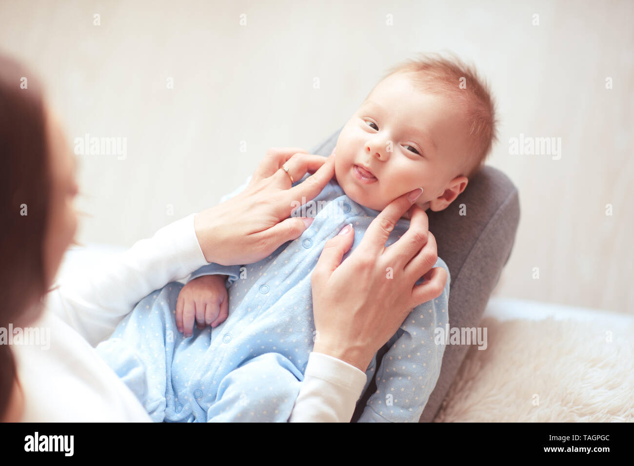 Lustige baby boy liegen auf Mutter hautnah. Mit Blick auf die Kamera. Mutterschaft. Ansicht von oben. Stockfoto