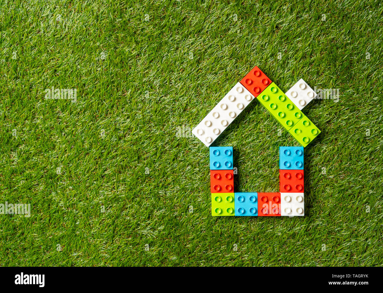 Konzeptionelle Bild der Kinder Spielzeug Bausteine Haus auf der grünen  Wiese top Ansehen und Kopieren in Property Investment Immobilien sparen und  kaufen home Stockfotografie - Alamy