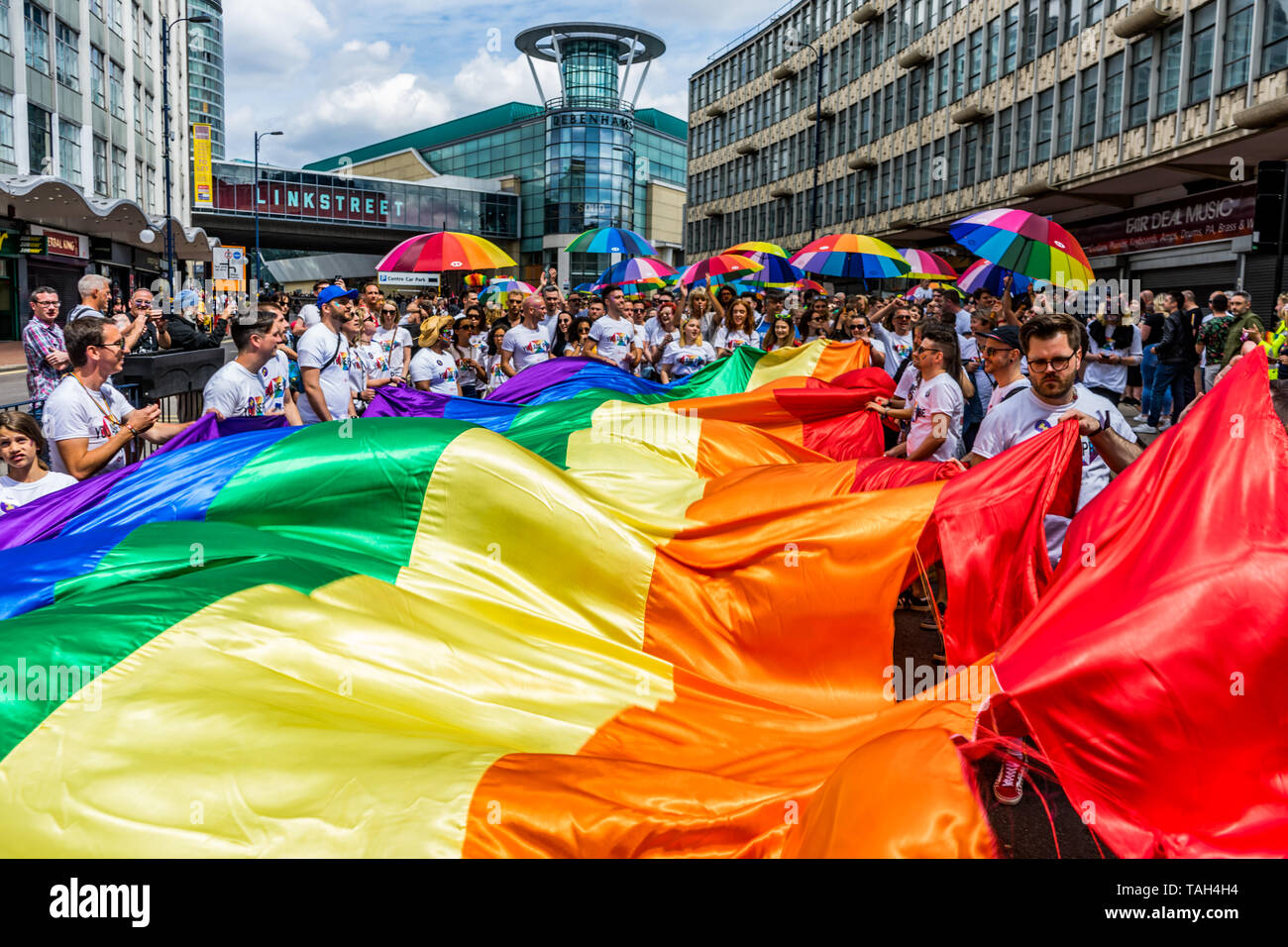 Mitglieder der LGBTQ Community werden gesehen, mit einem Regenbogen Flagge und Sonnenschirme während der Birmingham Pride Parade. Birmingham Stolz in diesem Jahr ist die umstrittene keine Außenseiter pädagogisches Programm, die Veranstalter sind zuversichtlich, dass in diesem Jahr das größte in seiner 22 jährigen Geschichte sein wird, mit dem größten muslimischen Kontingent je in Birmingham Stolz, ein jährliches Festival für die lgbtq Community in der Regel übernimmt die Spring Bank Holiday gesehen. Die Veranstaltung beginnt mit einem Umzug vom Victoria Square im Zentrum der Stadt das Gay Village in Hurst Straße. Stockfoto