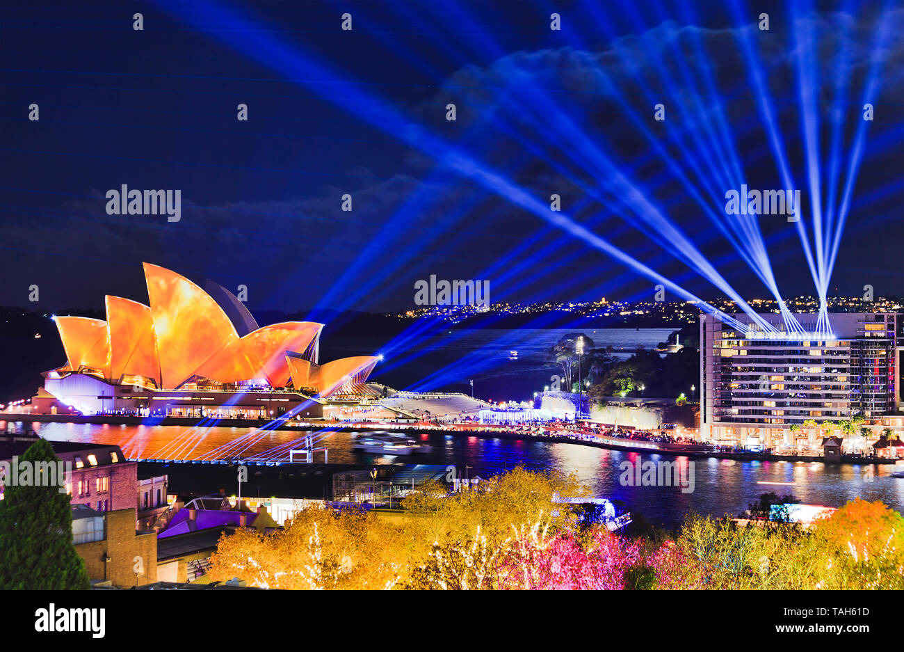 Generische moderne Architektur von Sydney CBD Stadtbild während Vivid Sydney Light Show hell beleuchtet auf buildigns rund um Hafen mit blauen Strahlen in Stockfoto
