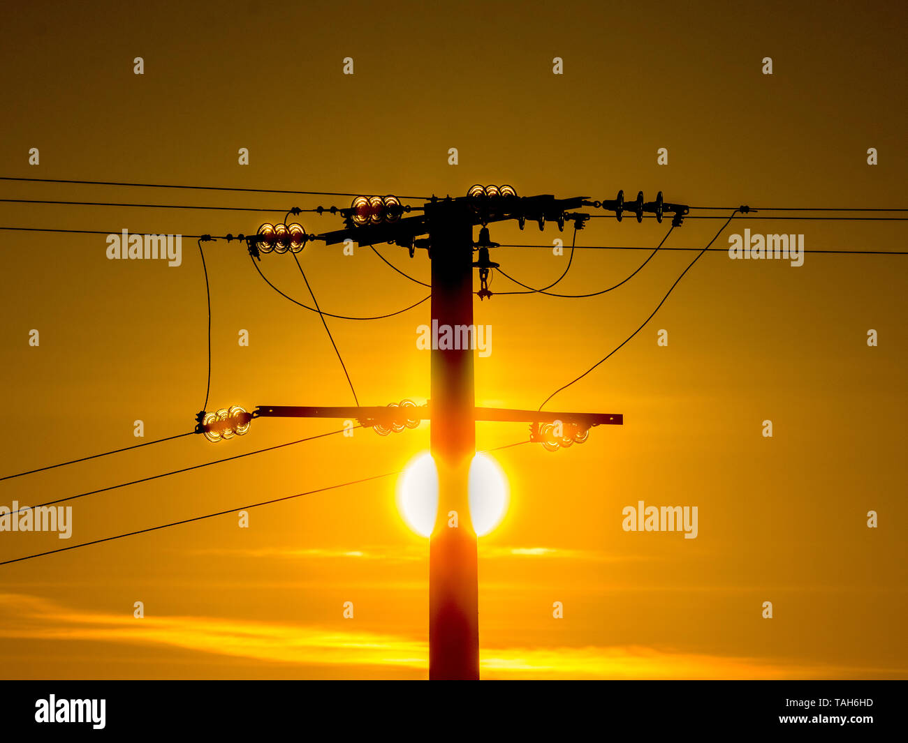 Sonnenaufgang hinter Strommasten - Frankreich Stockfoto