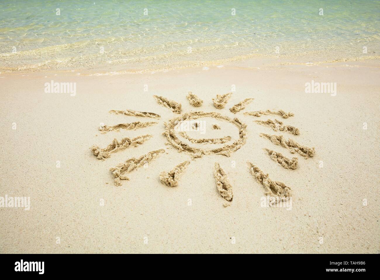 Nahaufnahme der lächelnden Sonne auf Sand in der Nähe des Meer am Strand Stockfoto