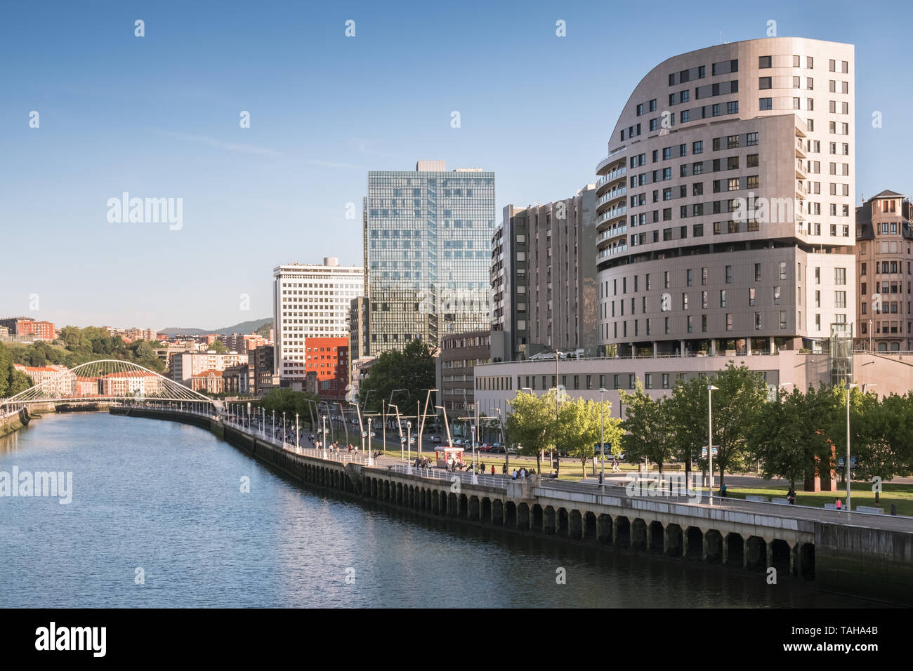 Moderne Architektur und Zubizuri Fußgängerbrücke neben den Fluss Nervion, Bilbao, Baskenland, Spanien. Stockfoto