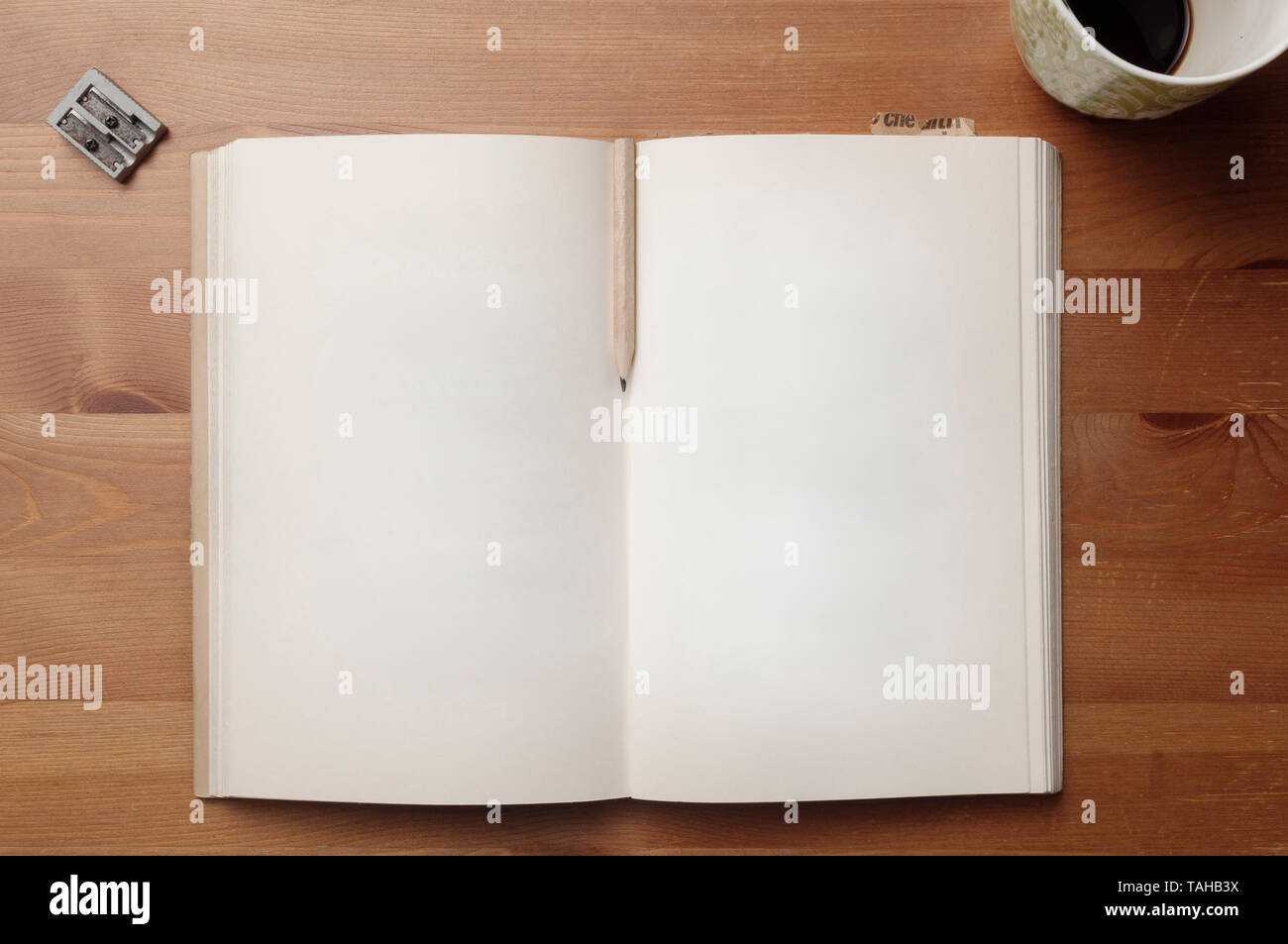 Alte leere Seiten Buch mit Bleistift und Papier zwischen den Seiten Lesezeichen auf einem Holztisch Stockfoto