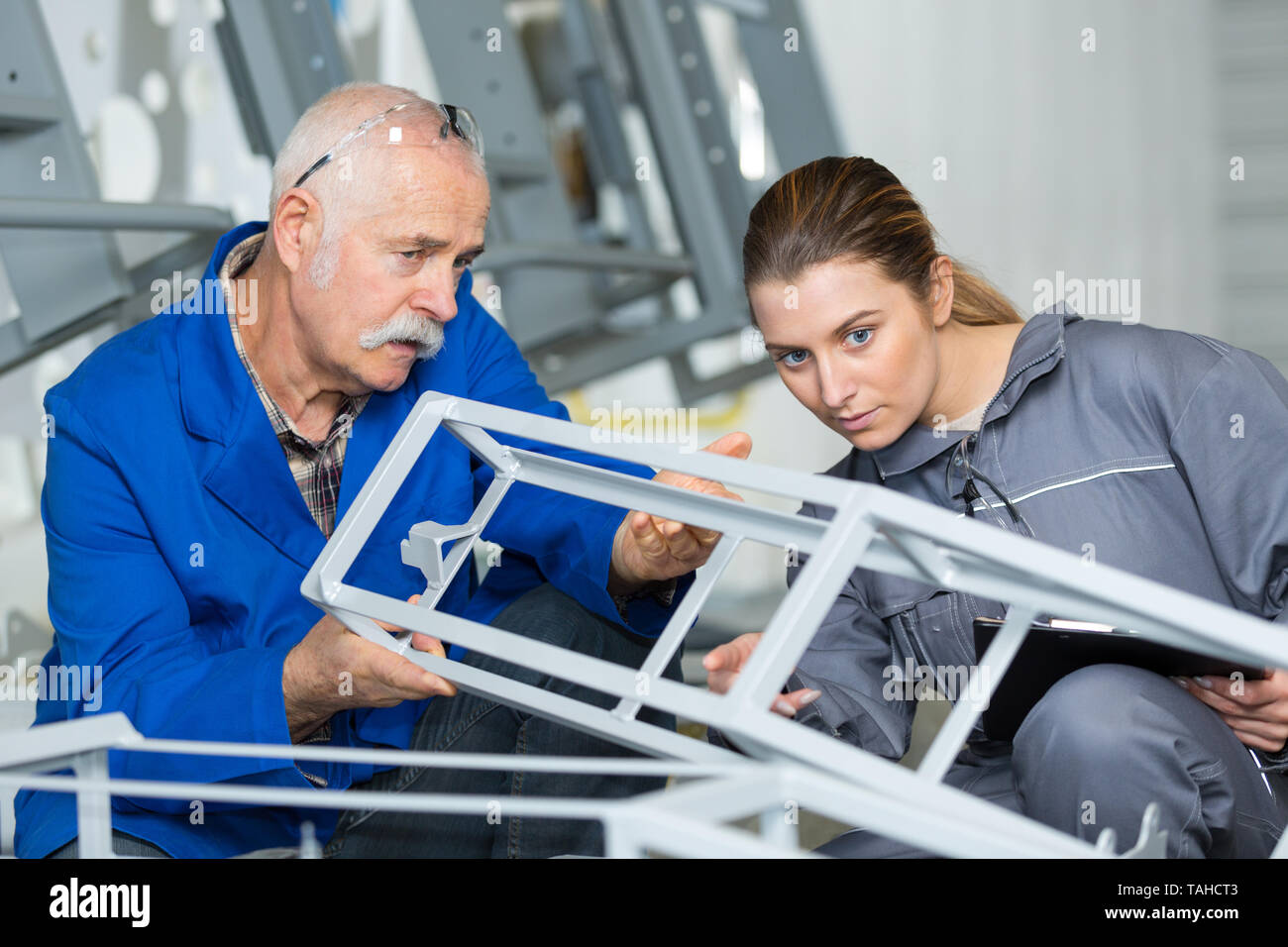 Ältere Arbeitnehmer und junge Kollegin Prüfung metall Struktur Stockfoto