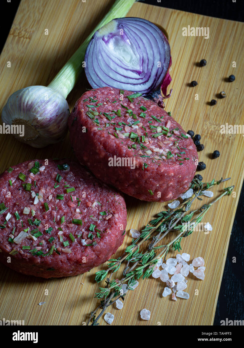 Beef Tatar burger Patty mit Zwiebel, Knoblauch, Thymian, Pfeffer und Himalaya Kristallsalz. Stockfoto