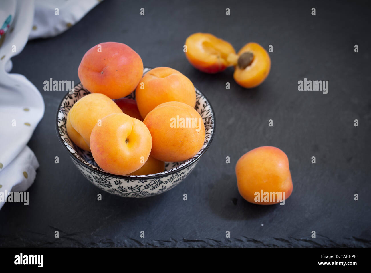 Aprikosen in Schüssel auf schwarzem Hintergrund Stockfoto