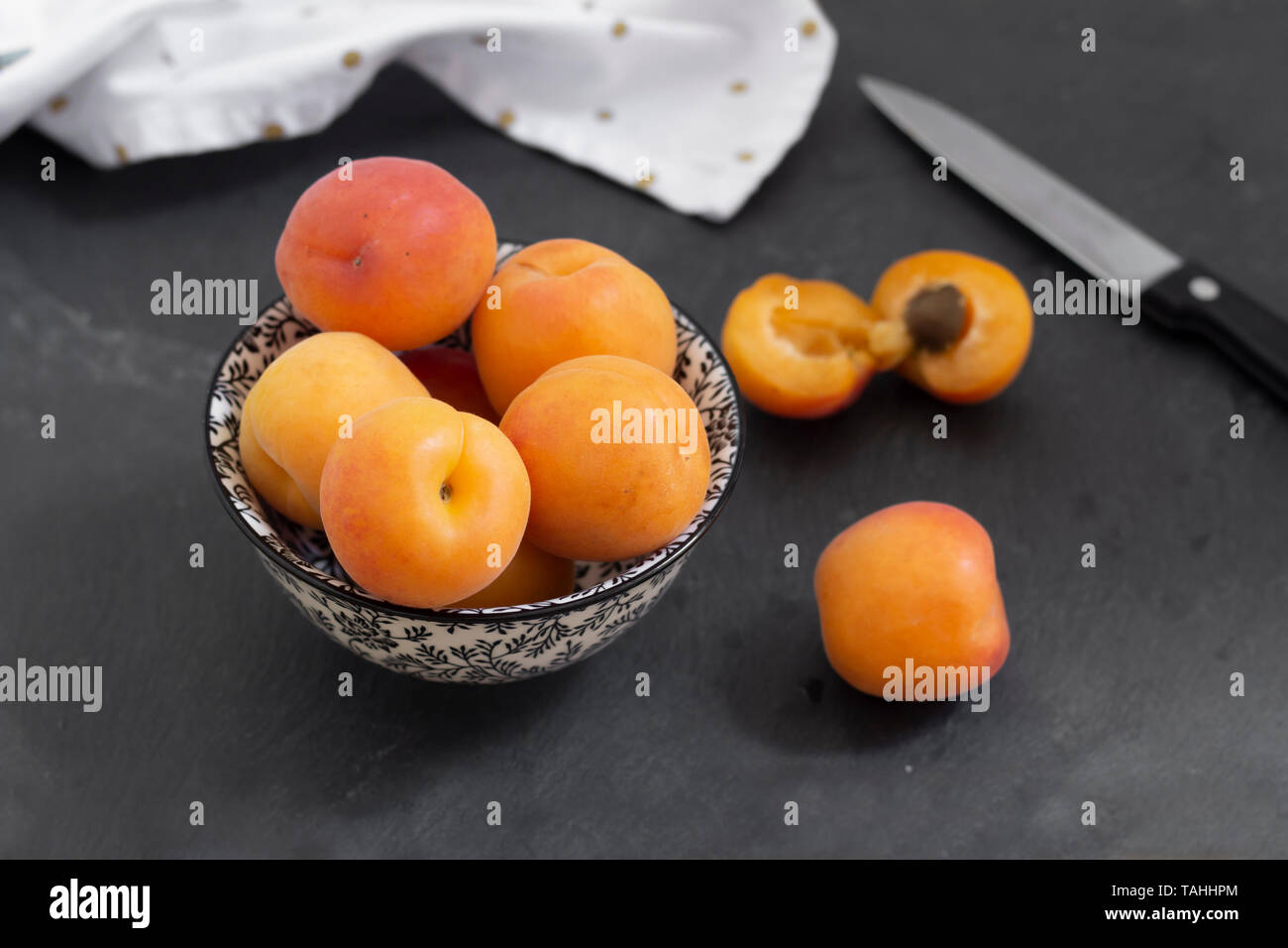 Frische Aprikosen mit Tuch und Messer Anordnung auf Tabelle Stockfoto