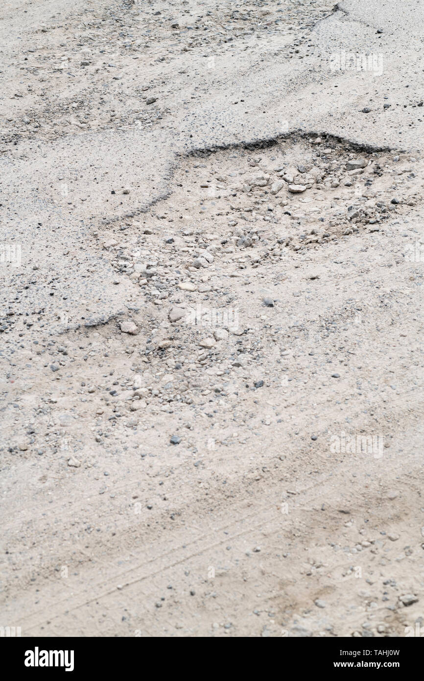 Schlagloch in einem Parkplatz am Meer. Konzept Unebener Untergrund, schlechte Wartung, kaputte Infrastruktur, schlechter Job, raue Straße voraus. Stockfoto