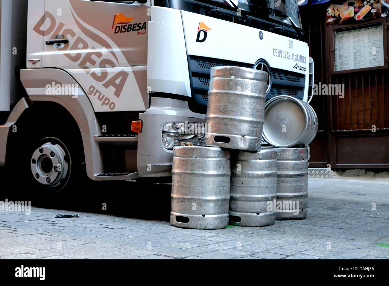 Leere Bierfässer auf der Straße vor einem Grupo Disbesa Lieferwagen in Madrid, Spanien abgelegt. Stockfoto