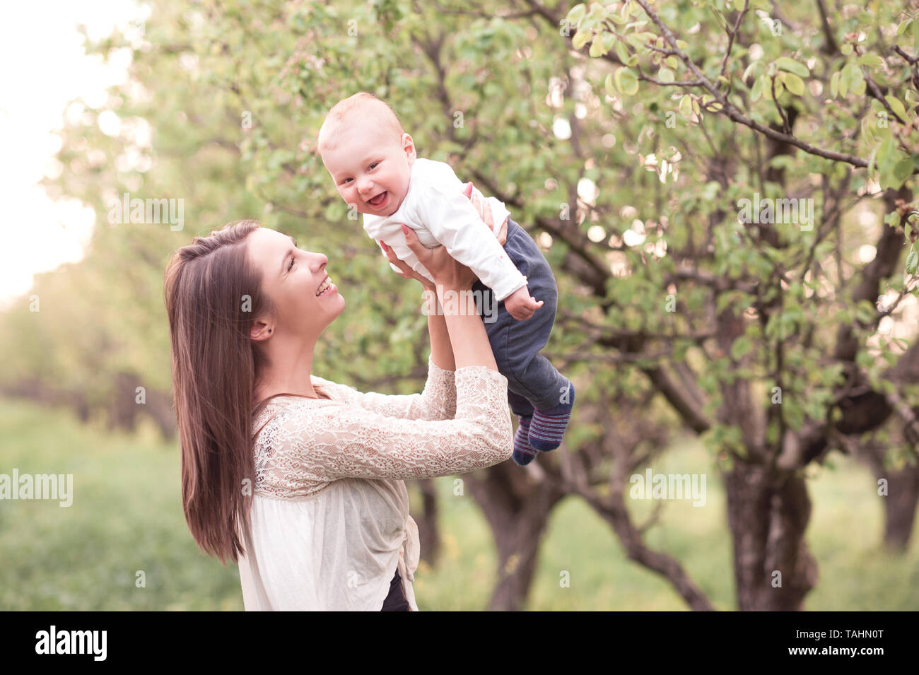 Lächelnde Frau mit Baby im Freien. Glück. Die Mutterschaft. Stockfoto