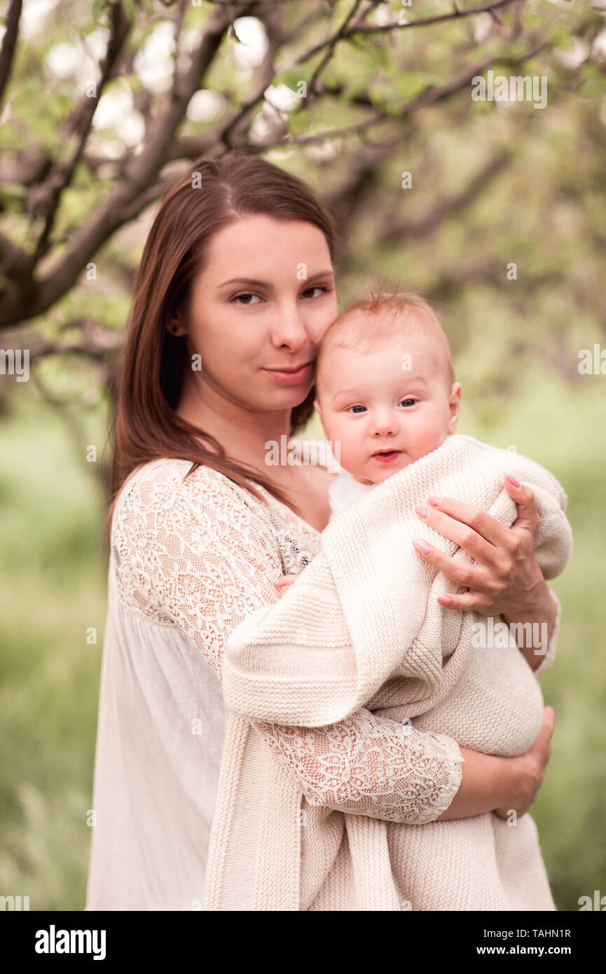 Schöne Frau mit baby boy im Freien. Mit Blick auf die Kamera. Glückliche Mutterschaft. Stockfoto