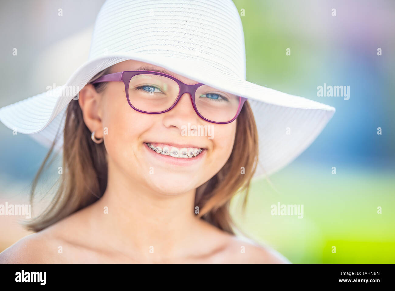 Glücklich lächelnde Mädchen mit Zahnspangen und Gläser. Kieferorthopäde und Zahnarzt Konzept. Stockfoto