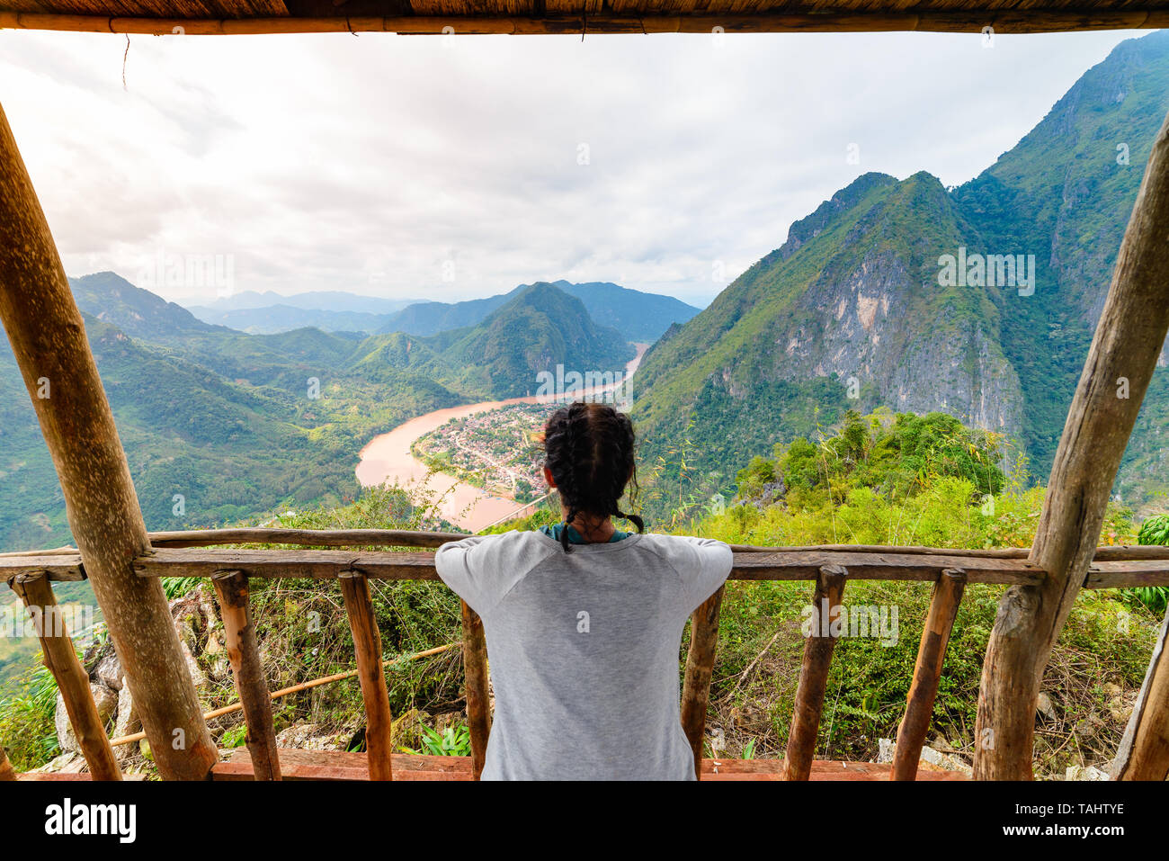 Frau auf Balkon aus Holz Eroberung Mountain Top in Nong Khiaw Nam Ou Fluss Tal Laos reife Menschen reisen millenials Konzept Reiseziel i Stockfoto