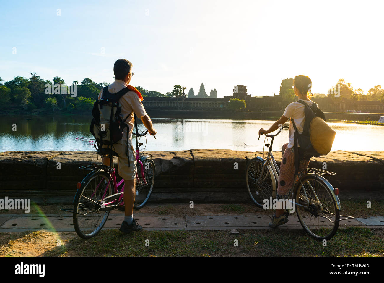 Touristische paar Radfahren im Tempel Angkor, Kambodscha. Angkor Wat Hauptfassade auf Wasser Teich wider. Umweltfreundliche Tourismus reisen. Stockfoto