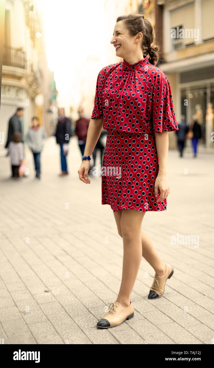 Glückliche Frau in Rot gekleidet viel gelacht in der Straße Stockfoto