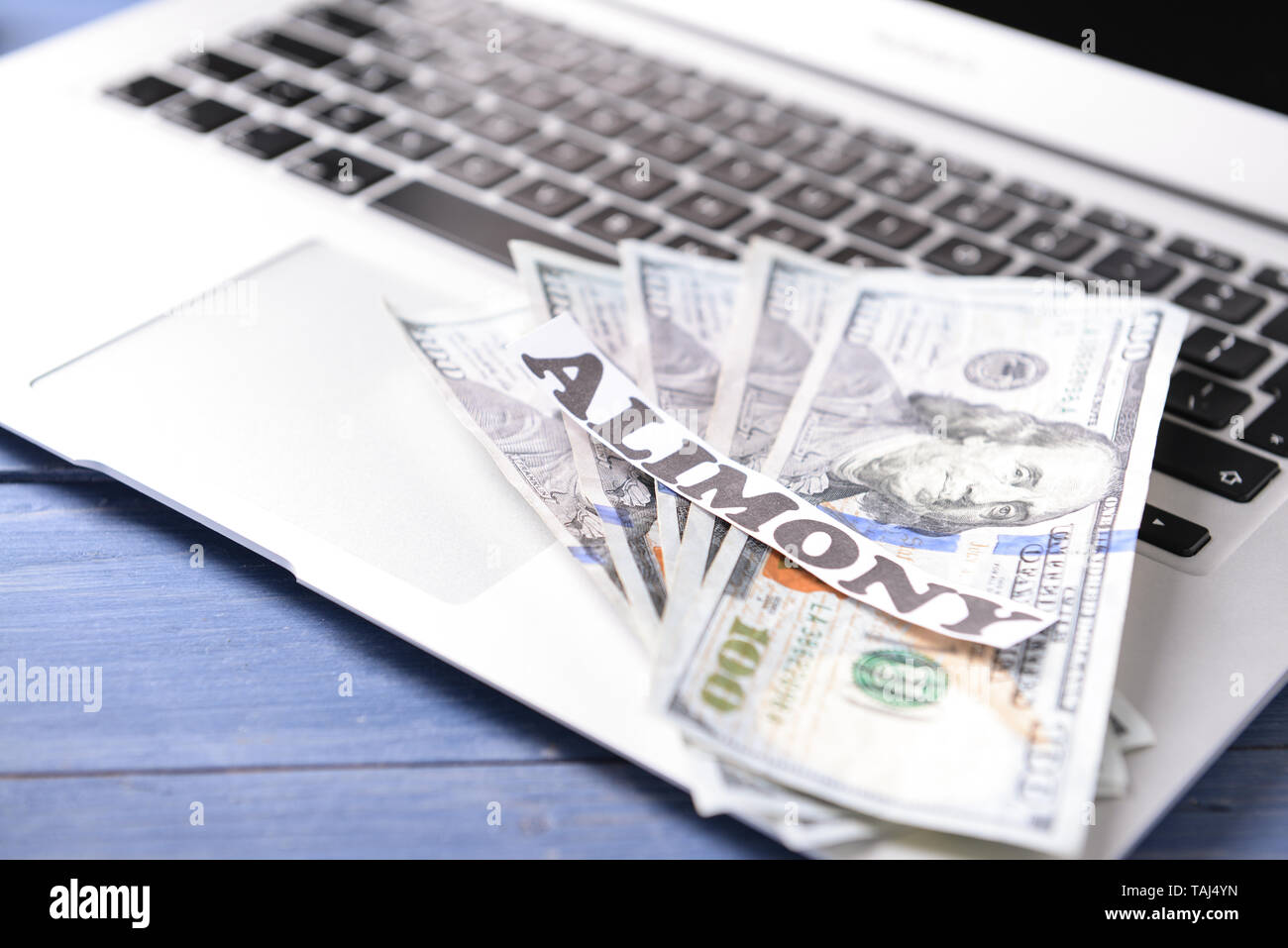 Laptop, Geld und Papier mit Text ALIMENTE auf Holztisch, Nahaufnahme Stockfoto