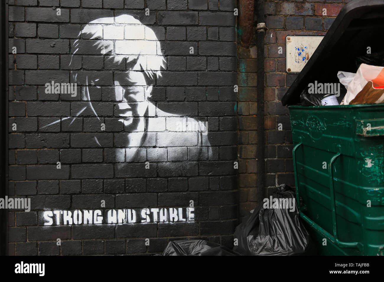 Birmingham, Großbritannien. 26 Mai, 2019. Ein Stück der Graffiti Kunst hat in der Nacht auf einer Straße Ecke in Birmingham scheinbar spöttisch emotionalen Resignation Rede des britischen Premierministers sowie TRONG von der Konservativen Partei 2017 Slogan und stabil" erschienen. Die Graffiti hat geschickt worden auf eine Mauer in Digbeth - einer heruntergekommenen Gegend von Birmingham City gesprüht. Die Arbeit erscheint wie eine Banksy - style politische Aussage und Gerüchte auf Facebook behaupten, es von einem lokalen Künstler Mohammed Ali Aerosol werden, obwohl dies nicht bestätigt werden kann. Kredit: Kredite: Peter Lopeman/Alamy leben Nachrichten Stockfoto