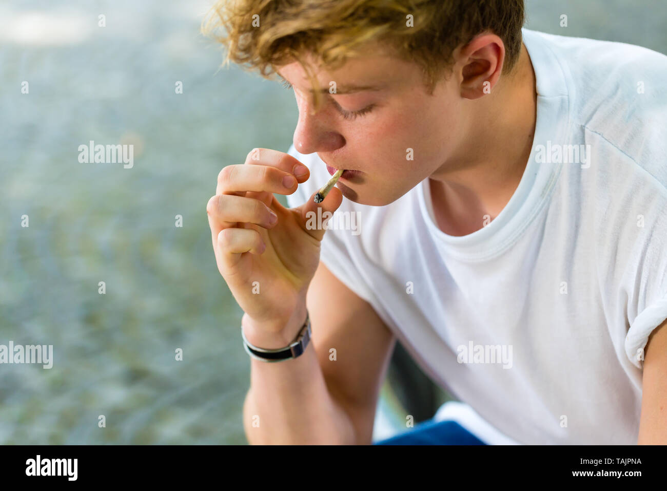 Seitenansicht des jungen Mann Rauchen im Freien Stockfoto