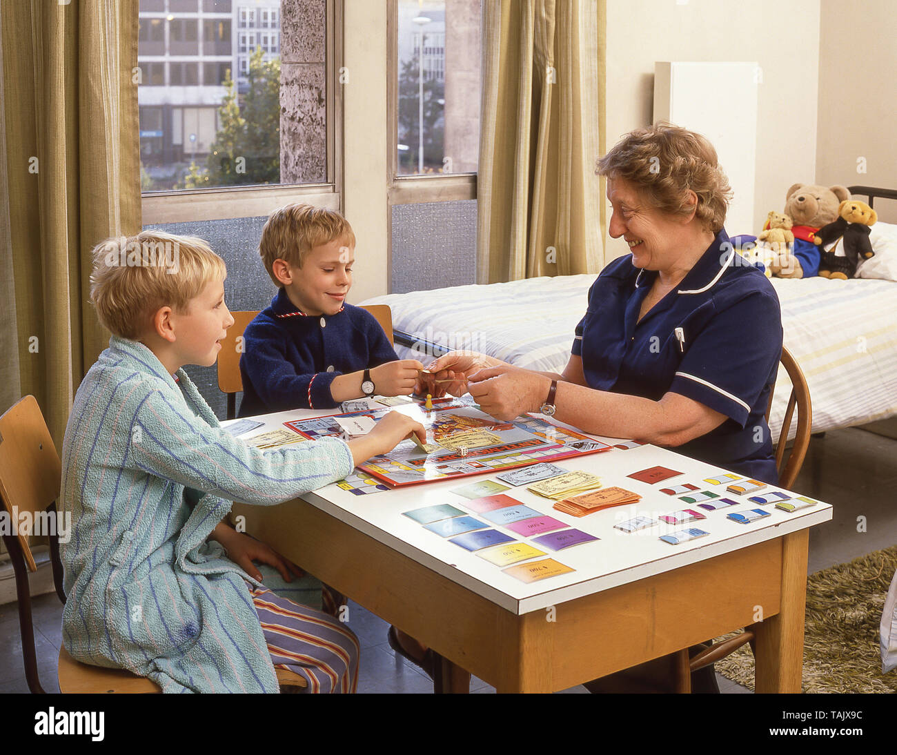 Haus Matrone spielen Brettspiel mit Boarding School Jungen, Guildford, Surrey, England, Vereinigtes Königreich Stockfoto