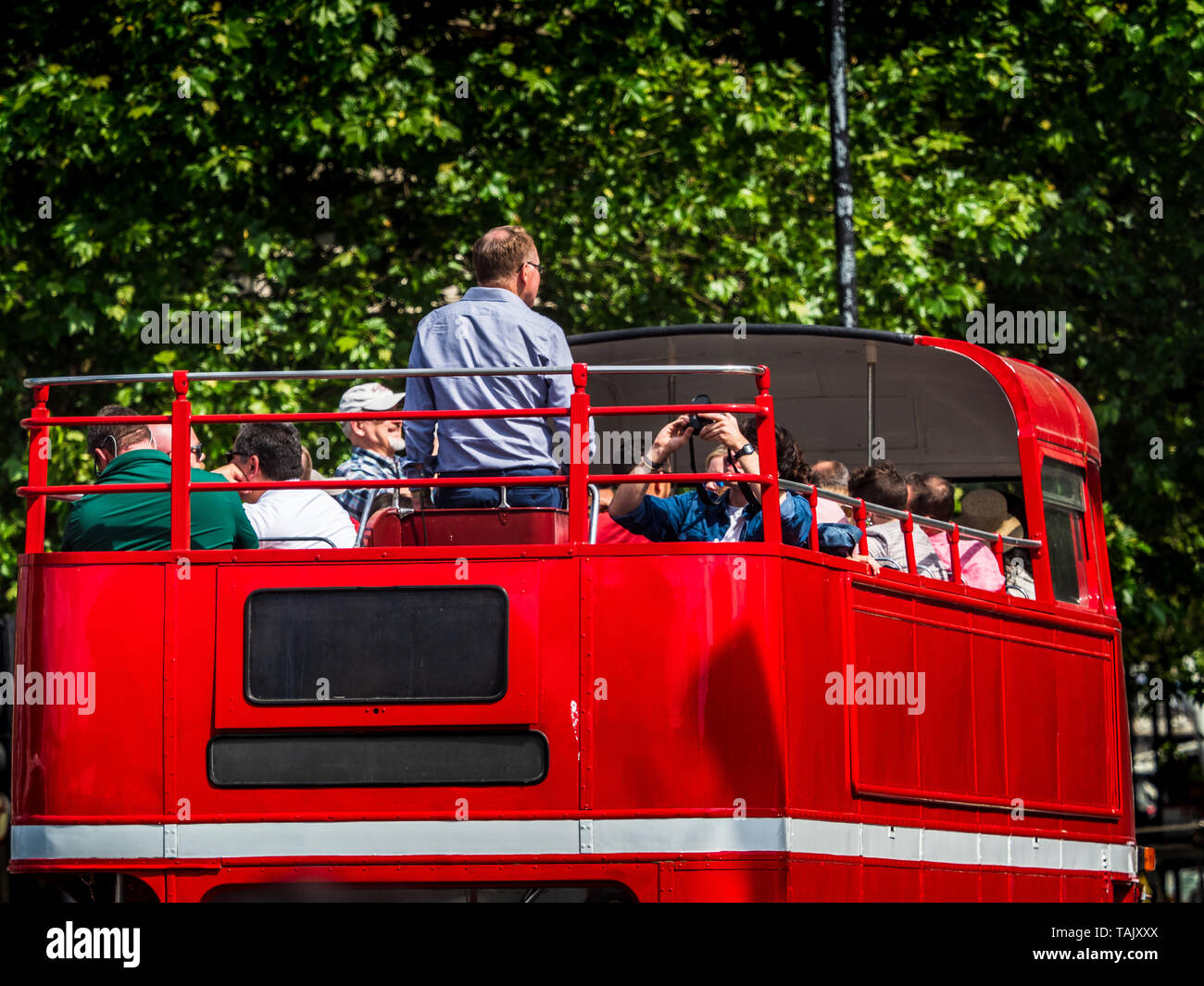 London Tour Bus Guide spricht mit Touristen auf dem oberen Deck eines klassischen Londoner Routemaster Bus Stockfoto