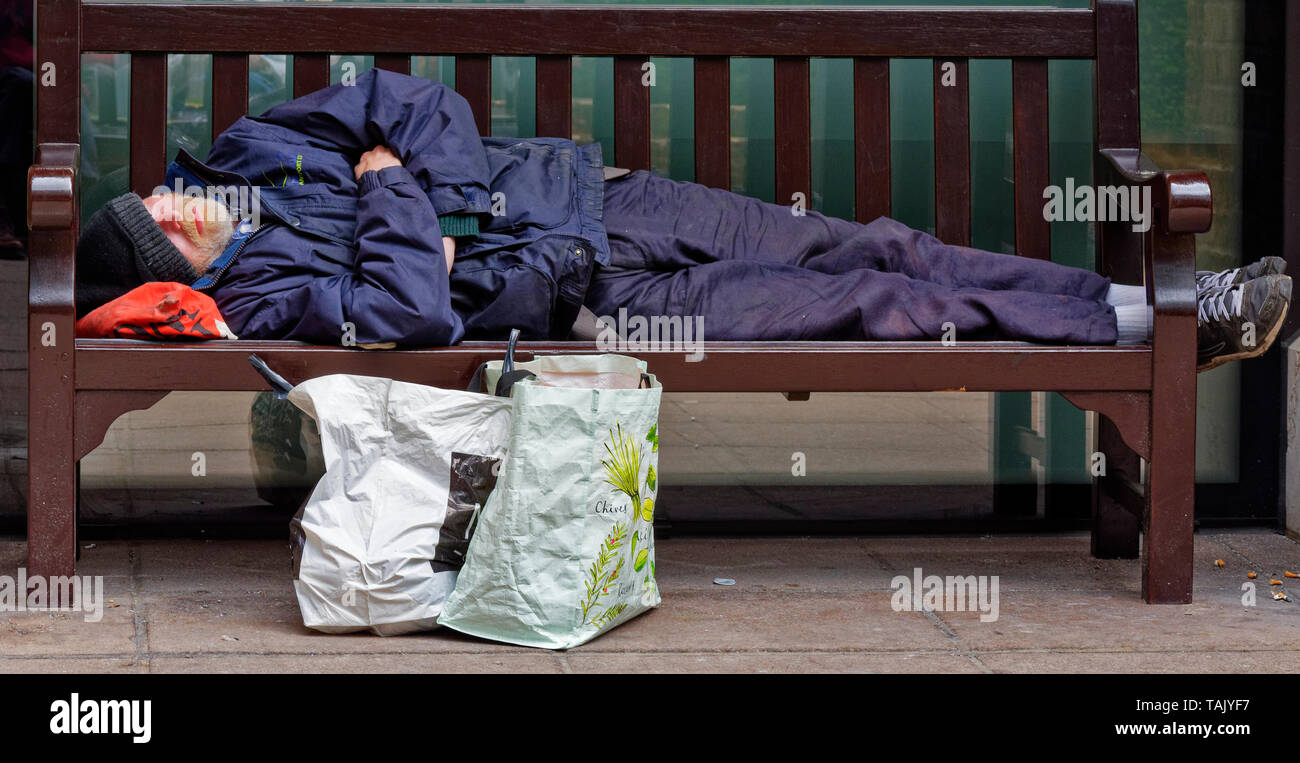 LONDON DIE STADT LONDON OBDACHLOSEN auf einer Parkbank schläft Stockfoto