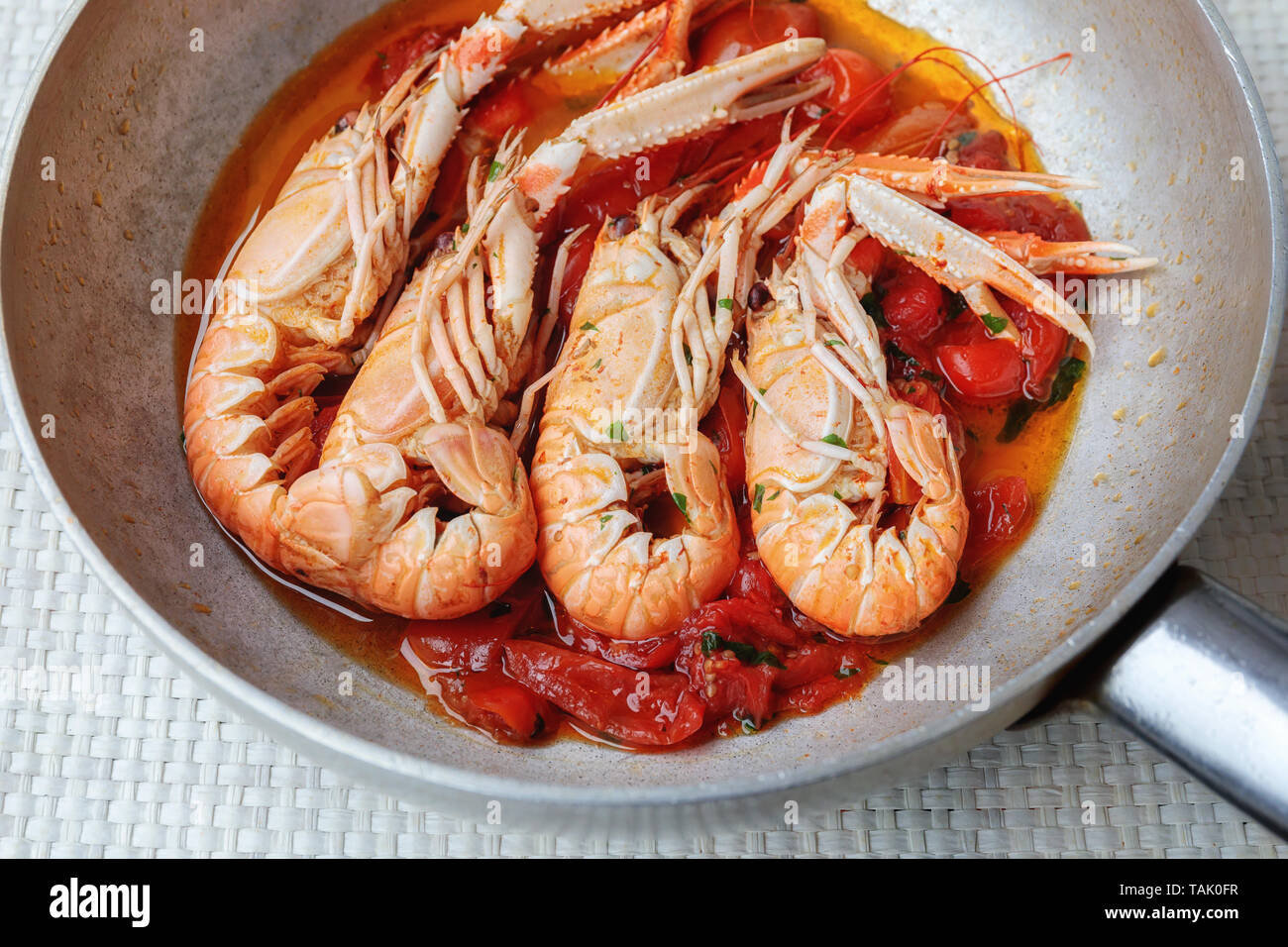Scampi, Zubereitung und Kochen in der Pfanne. Schalentiere Garnelen in  einer Pfanne mit Tomaten gekocht Stockfotografie - Alamy