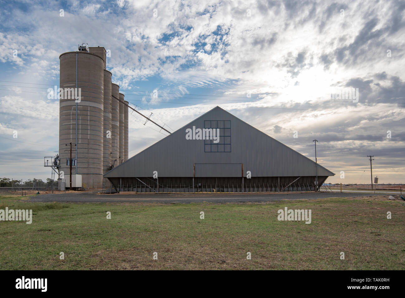 Am späten Nachmittag Wolken über den Silos und Bunker neben der Bahnlinie in der Stadt von Burren Kreuzung im Nordwesten von New South Wales, Australien Stockfoto