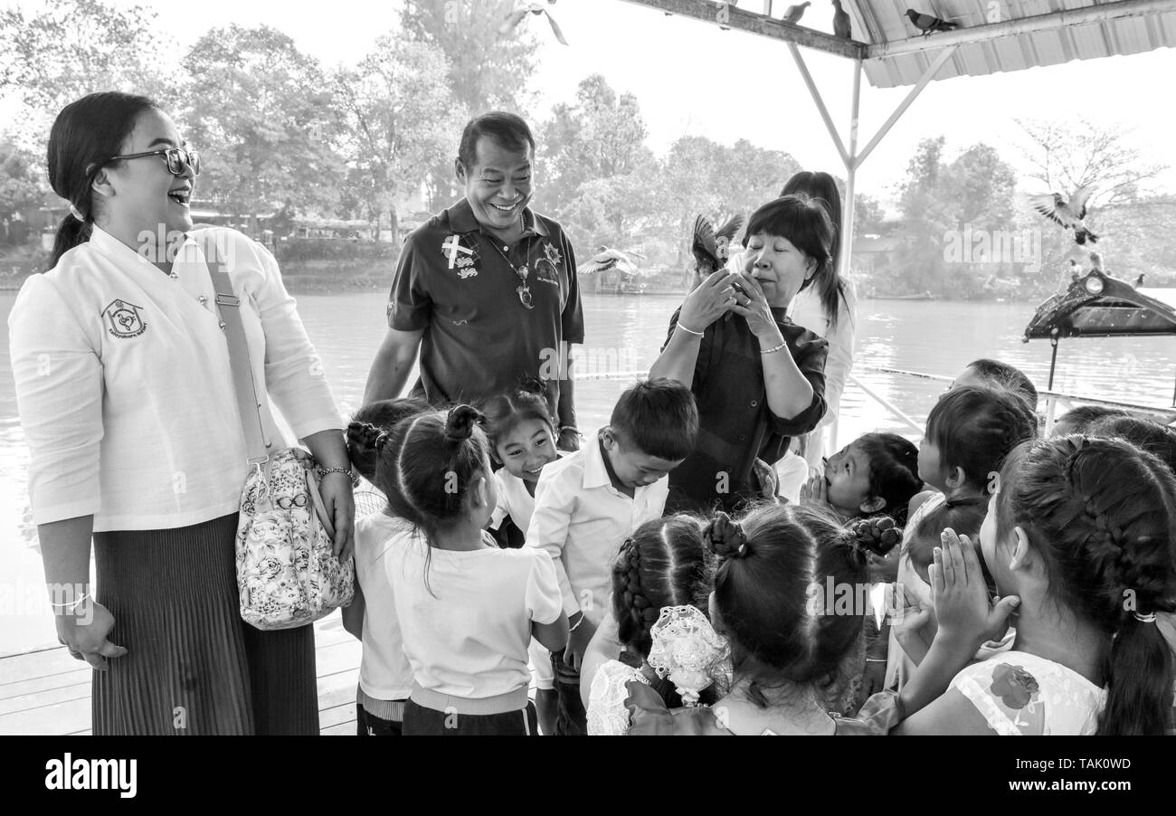 Thai Kinder und ihre Erzieher release Vögel neben Fluss Ping Chiang Mai. In der buddhistischen Religion, einige Leute glauben, dass eine Freigabe der Tiere wieder in der Natur Hilfe kann eine individuelle Verdienst erwachsen. Stockfoto