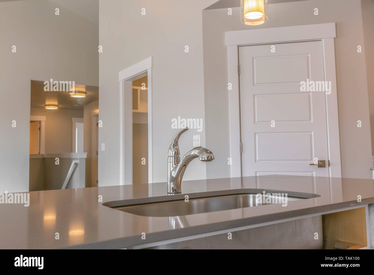 Nahaufnahme der saubere und glänzende Spüle in der Küche des neuen Hauses. Mehrere Türen, die zu verschiedenen Räumen kann im Hintergrund gesehen werden. Stockfoto