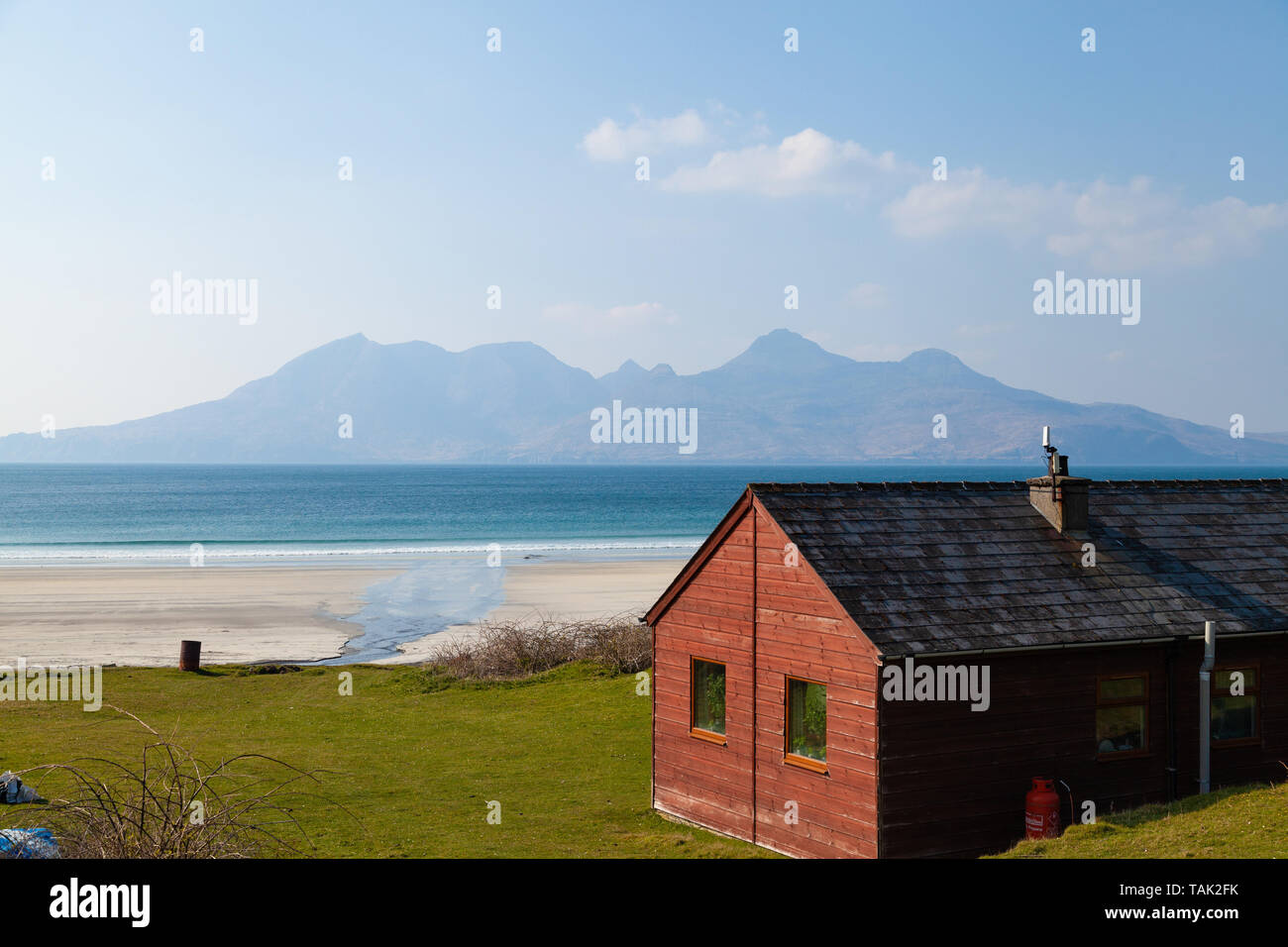 Eine Holzhütte in der Bucht von laig auf der Isle of Eigg, mit Rum in der Ferne. Stockfoto