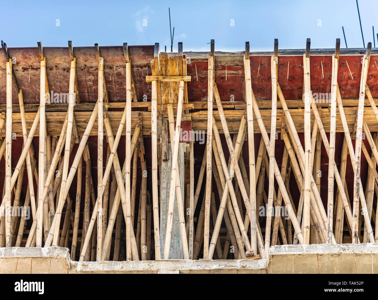Ein Bambus Gerüst verwendet eine verstärkte Zement Beton Dach Tafel zu unterstützen. Die neu gegossen Dach ist nach links für ca. 7 Tage zu kurieren. Indien. Stockfoto