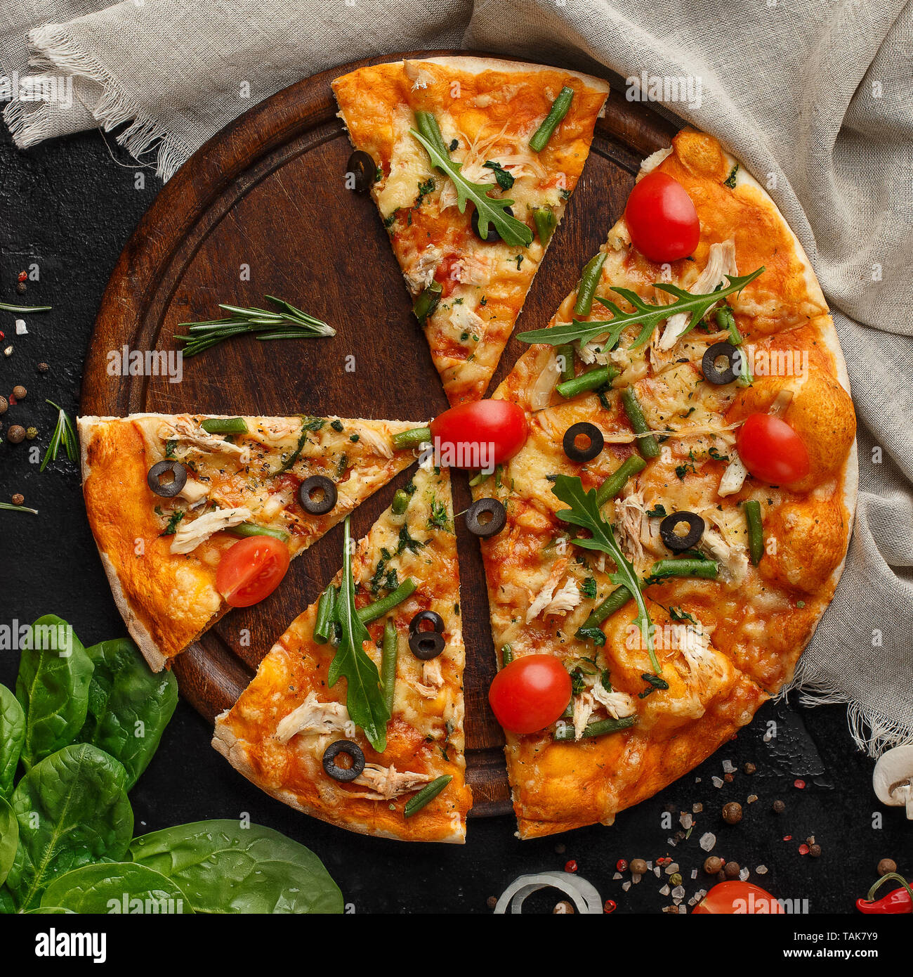 Leckere Pizza mit Gemüse und Kräutern auf Holzbrett Stockfoto