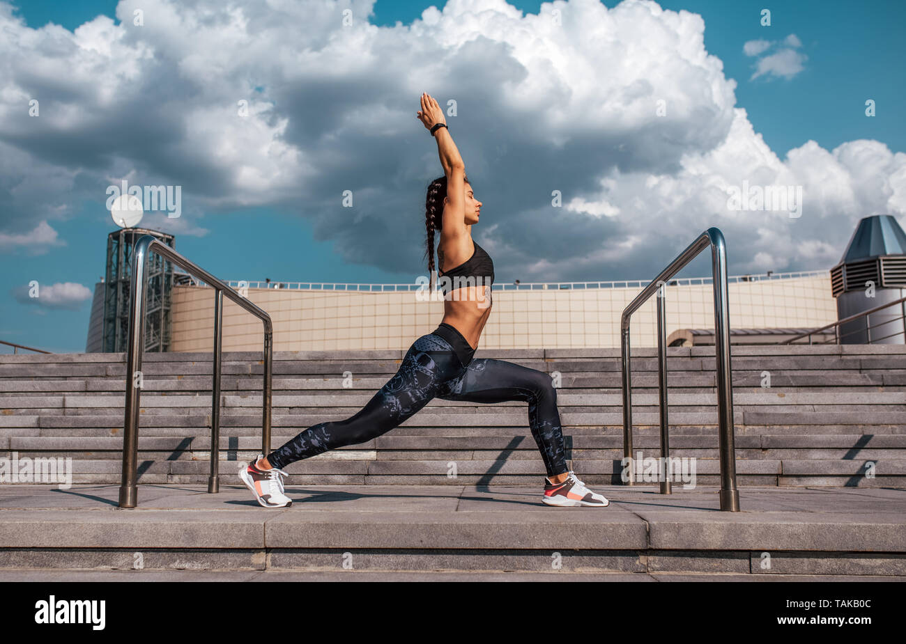 Sport Mädchen stürzt in den Sommer in der Stadt, Yoga. Sportswear leggings top Sneakers, Frau in Harmonie. Hintergrund Wolken Schritte Stockfoto