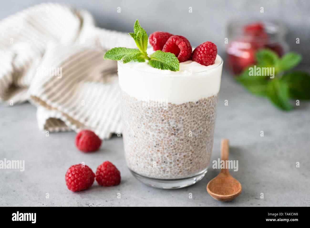 Vegetarische chia Pudding mit Joghurt mit Himbeeren im Glas auf konkrete Tabelle. Gesunde Lebensweise, gesunde Ernährung, Gewichtsreduktion, fitness Menü essen Stockfoto