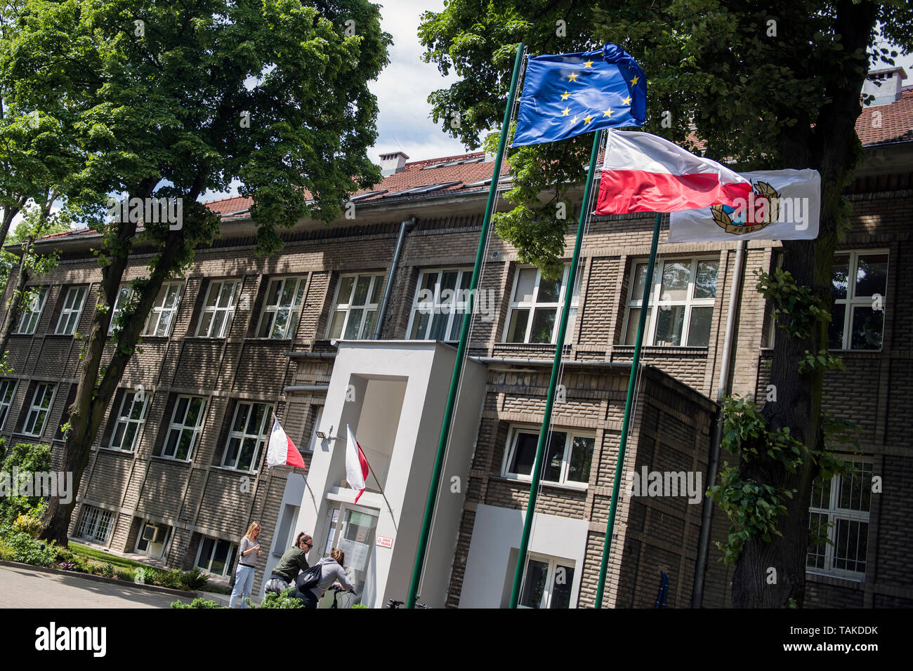 Blick auf den Eingang einer Schule mit der EU und der Polnische Flagge, in denen die Bürgerinnen und Bürger können ihre Stimmen während der EU-Wahlen. Wahlen zum Europäischen Parlament in Warschau, Polen. Stockfoto