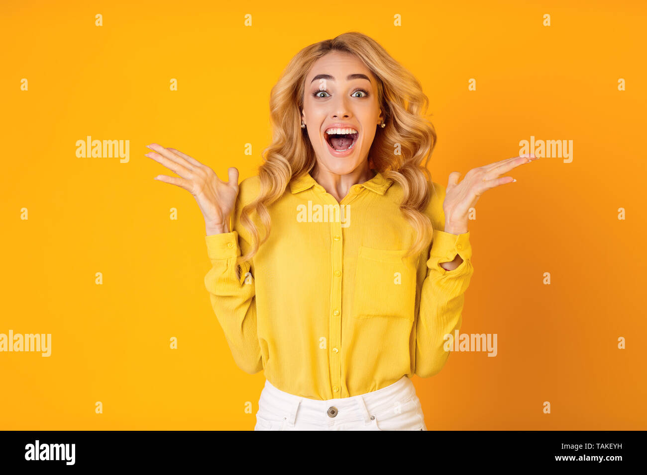 Aufgeregt tausendjährigen Frau schreiend auf gelbem Hintergrund Stockfoto