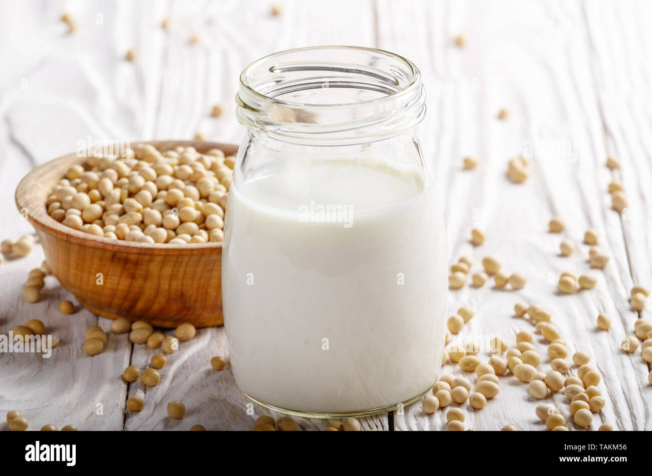 Pflanzliche alternative Soja Milch oder Joghurt in Mason jar auf weissem  Holztisch mit Sojabohnen in der Schüssel beiseite Stockfotografie - Alamy
