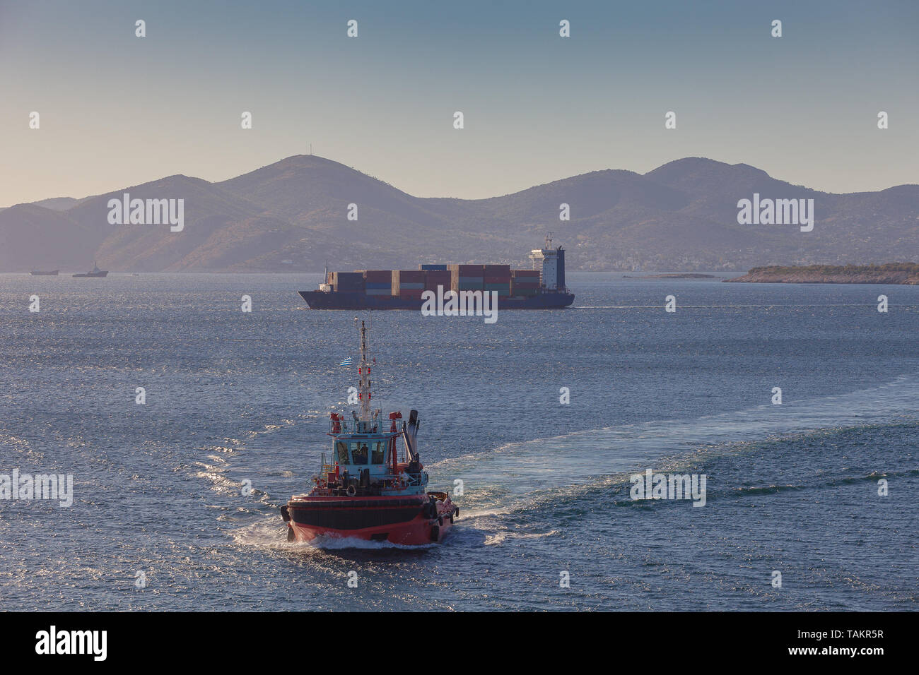 Containerschiff und Tugboat vor dem Hafen von Piräus, Athen, Griechenland Stockfoto