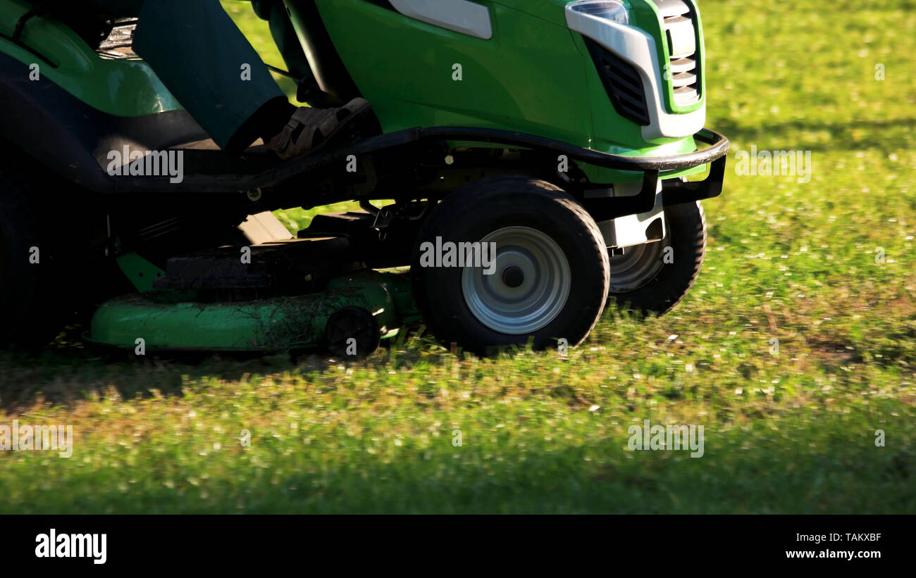 Grüne Rasenmäher Traktor. Schneiden den Rasen mit dem Rasenmäher. Stockfoto