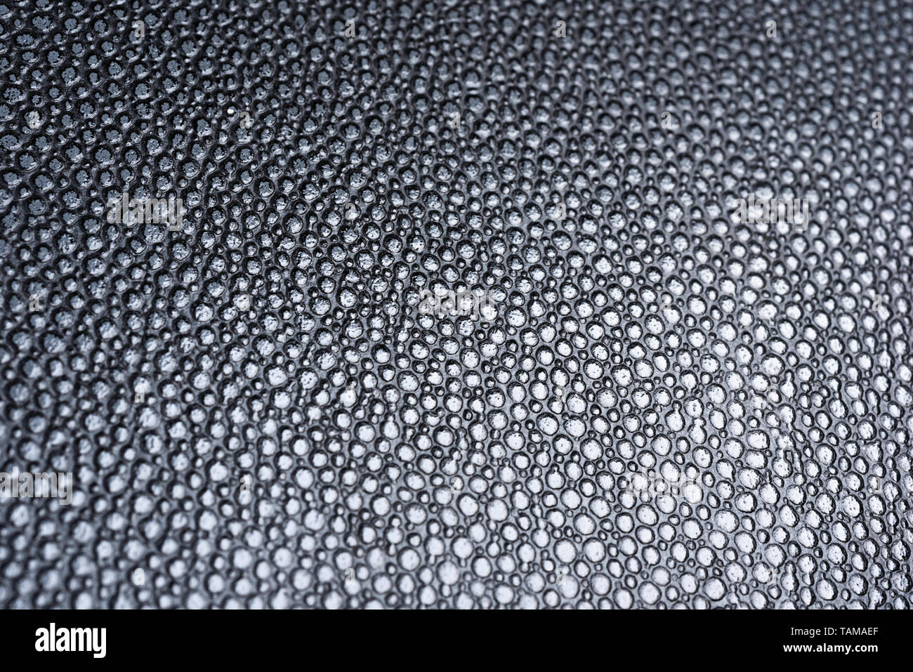 Die Textur einer schwarz Kunstleder mit klaren Details unter einem abgestuften Beleuchtung. Stockfoto