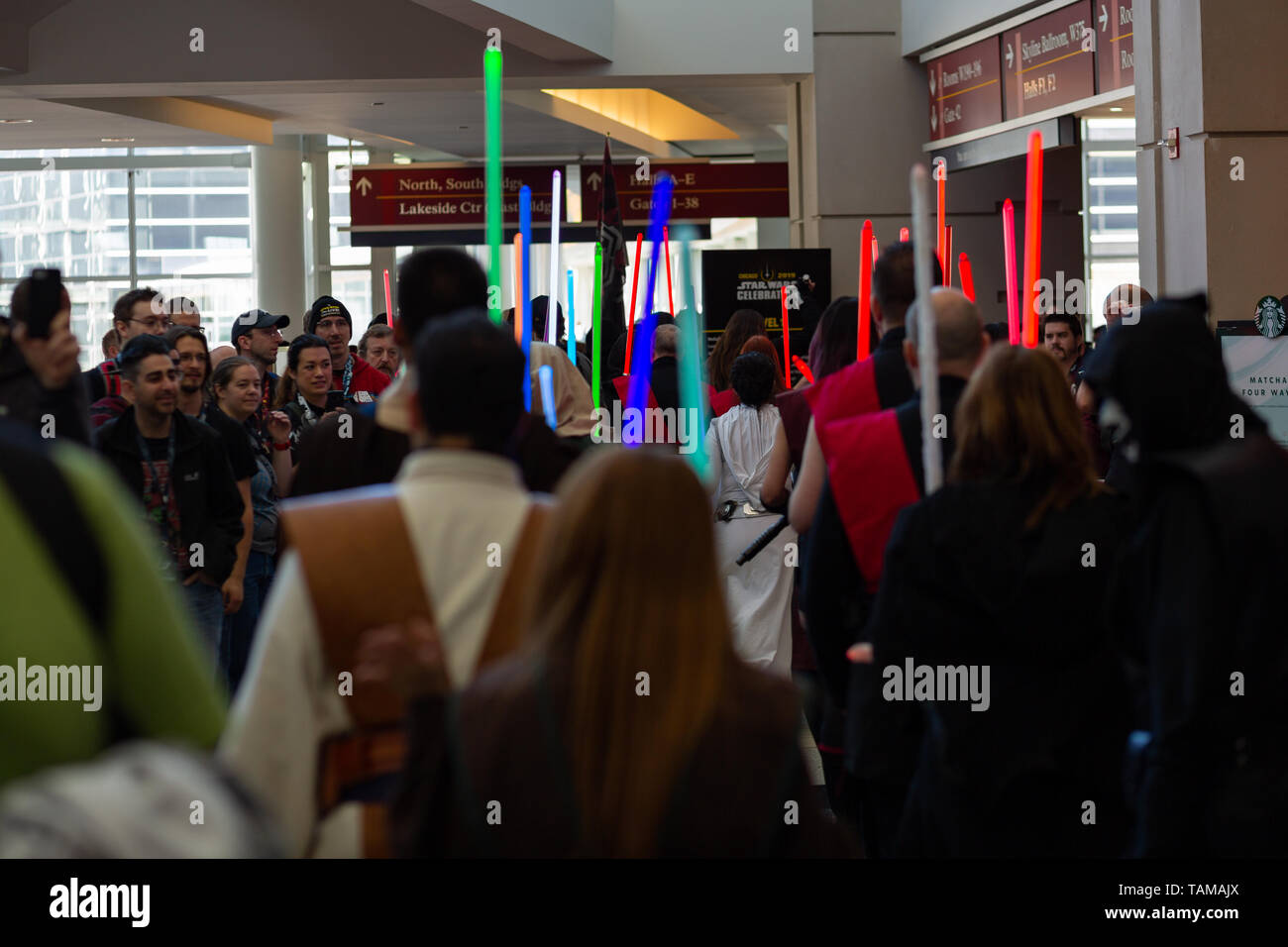 Die Menschen halten sich bunte Lichtschwerter im Cosplay Kostüme bei Star Wars Celebration 2019 - Chicago, IL Stockfoto