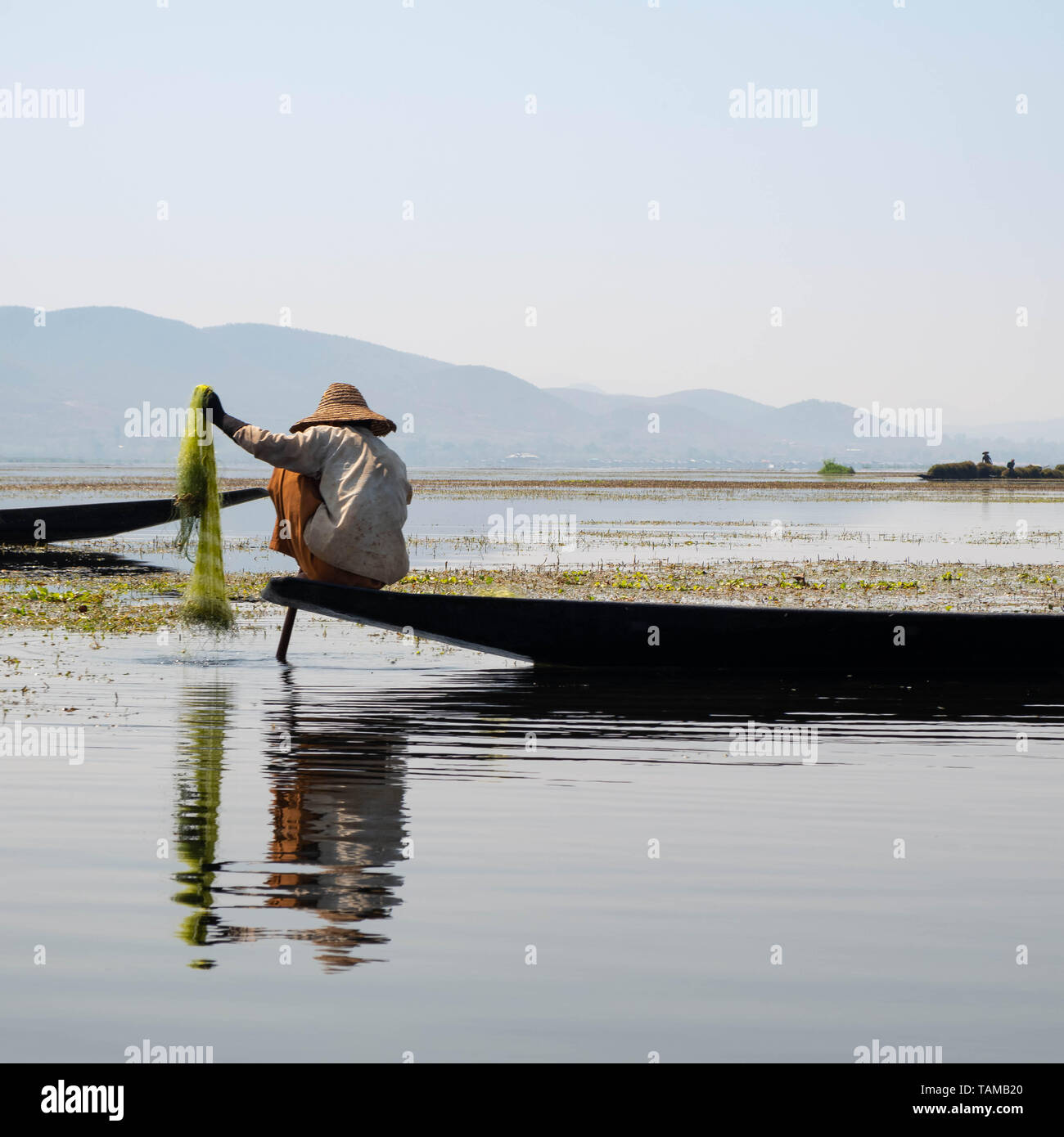 Man Fische mit einem Netz auf dem Inle See, Myanmar Stockfoto
