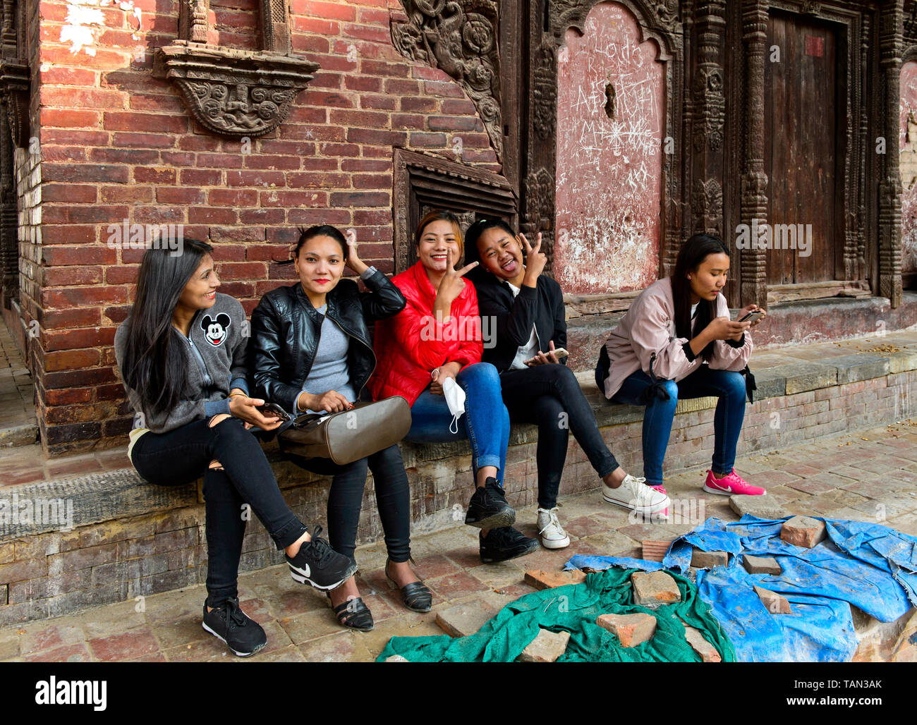 Lächelnden jungen Nepelese Frauen sitzen auf der Treppe vor der Jagannath Tempel, Hanumandhoka Durbar Square, Kathmandu, Nepal Stockfoto