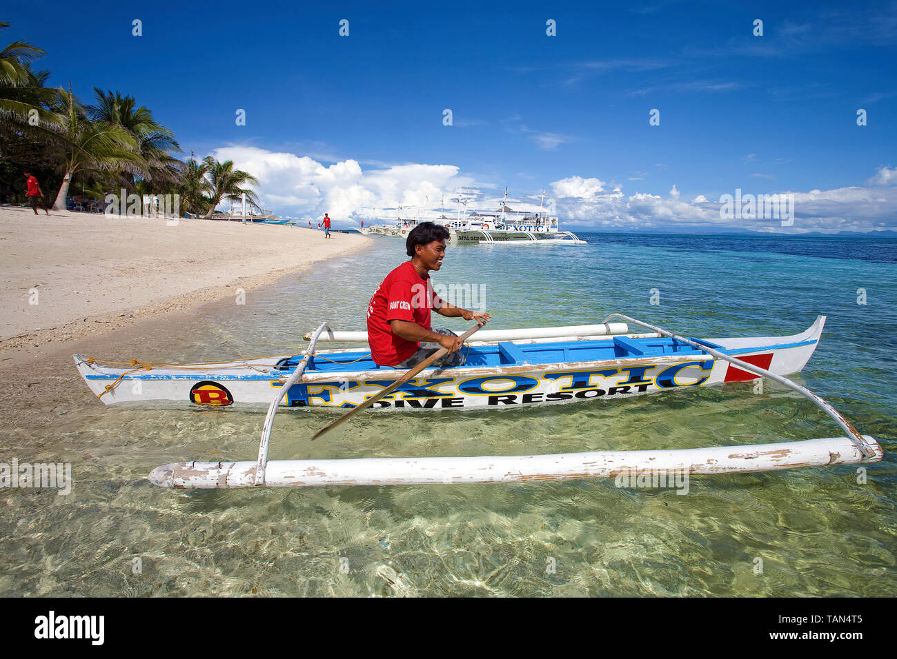 Filipino in ein kleines Auslegerboot an Bounty Beach, Insel Malapascua, Cebu, Philippinen Stockfoto