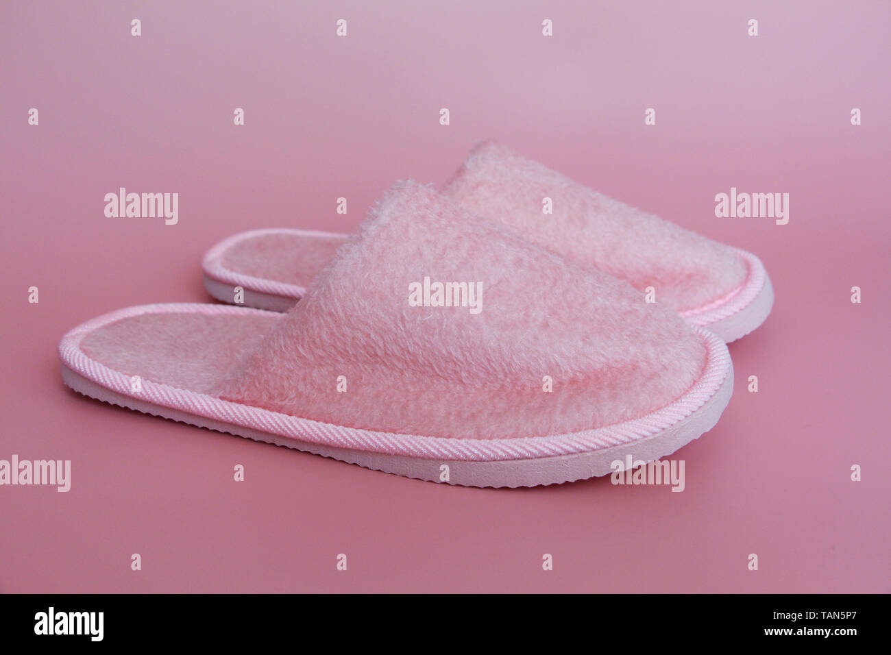 Rosa Hausschuhe auf einem rosa Hintergrund. Ein paar Haushalt terry Hausschuhe. Nichts mehr. Stockfoto