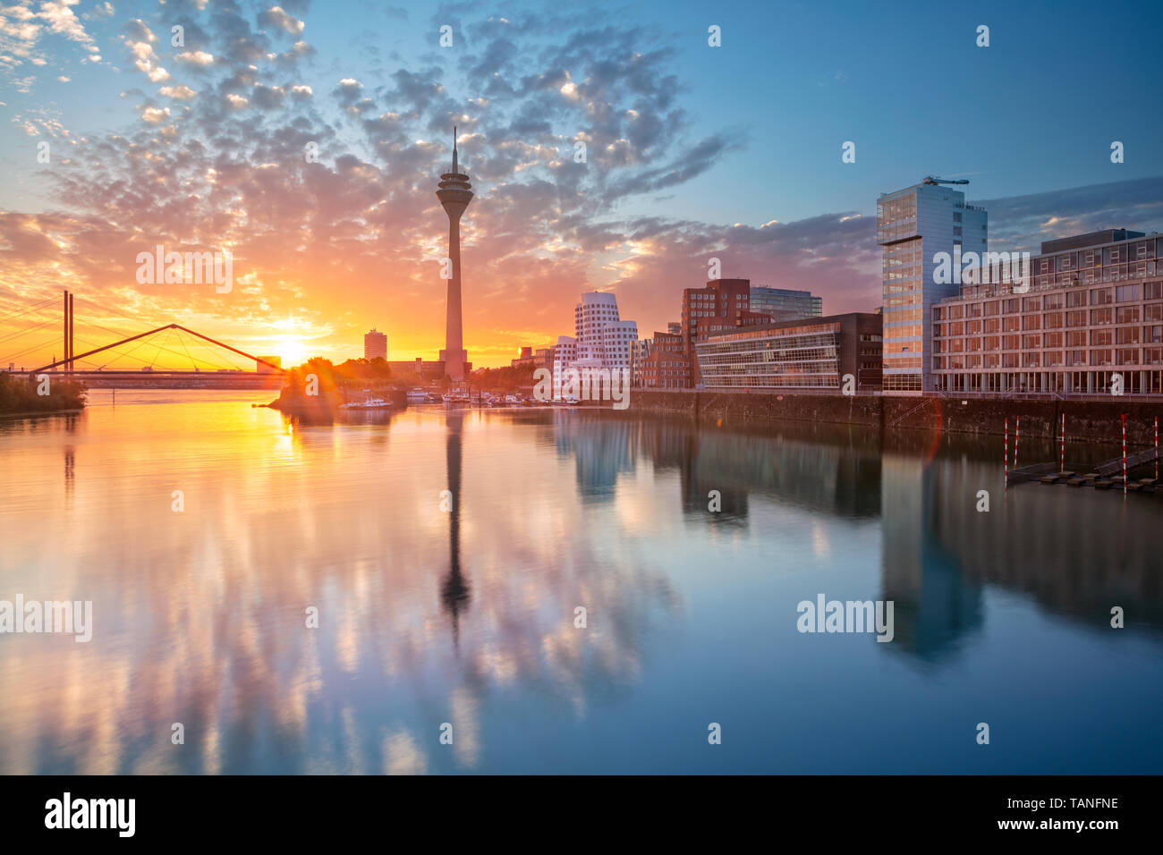 Düsseldorf, Deutschland. Stadtbild von Düsseldorf, Deutschland mit dem Medienhafen und Spiegelung der Stadt am Rhein, bei Sonnenaufgang. Stockfoto