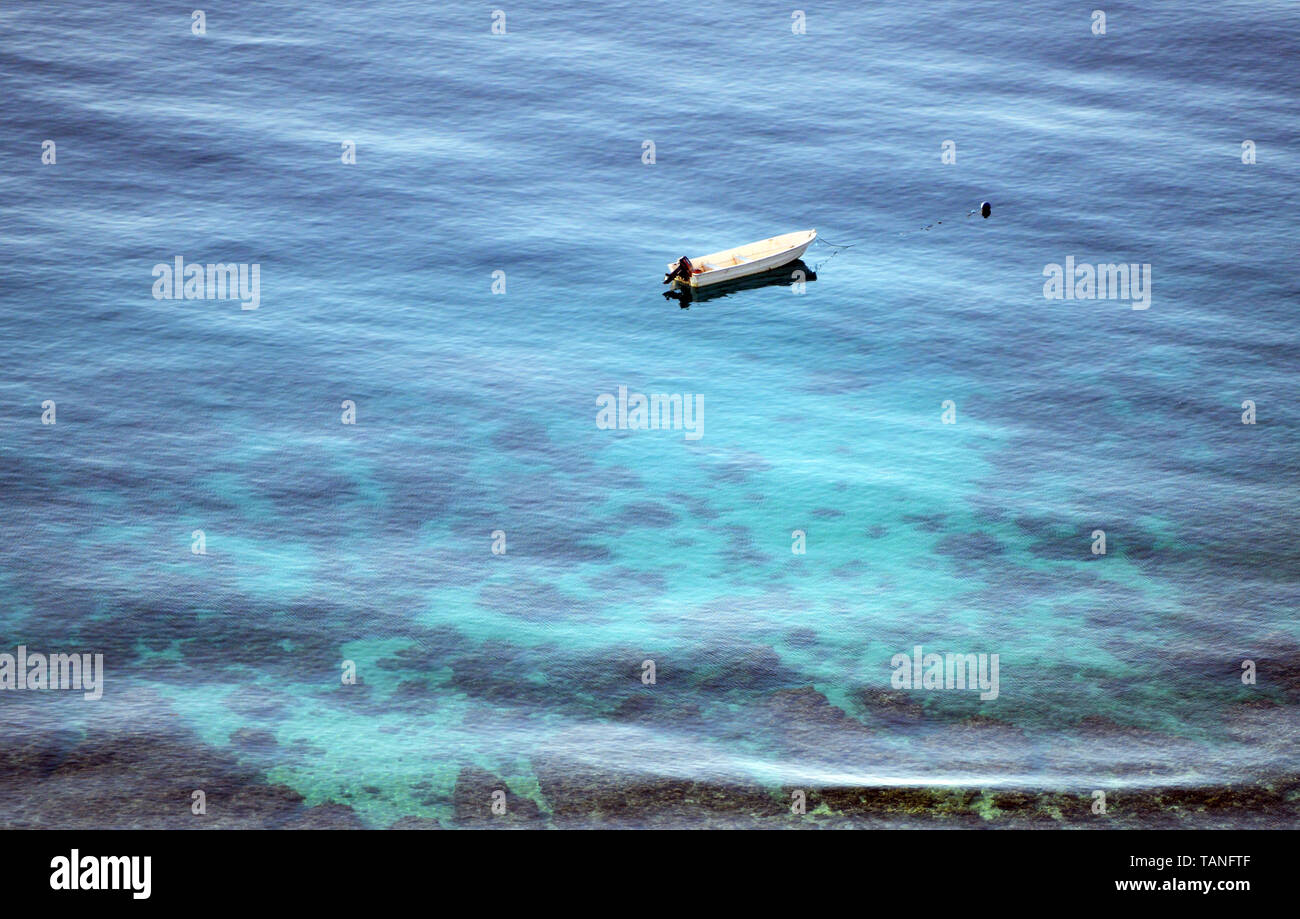 Ein Boot über die Korallenriffe der Sebayur Besar Insel. Stockfoto