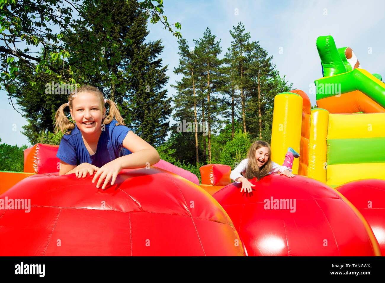 Glückliche kleine Mädchen haben viel Spaß beim Springen von Kugel zu Kugel auf ein Haus aufpumpen. Stockfoto