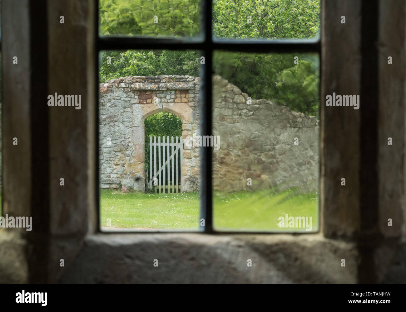 Ein Tor in der Wand, aus einem Fenster der alten Glas Cleeve Abbey, Somerset gesehen Stockfoto